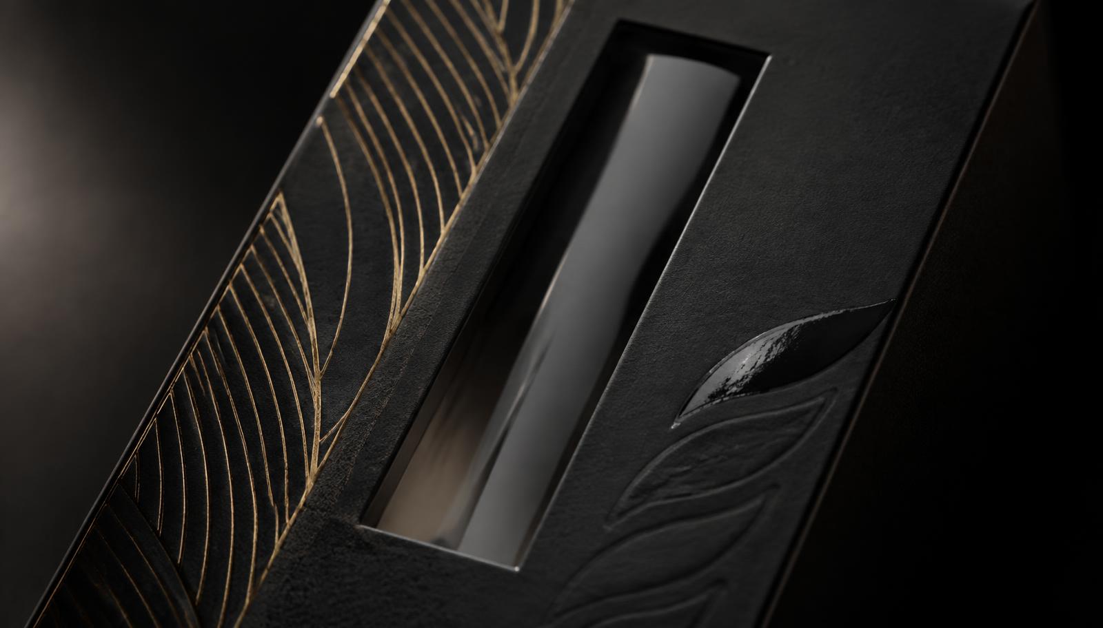 Macro detail of a matte black rigid CBD box with gold foil line pattern, spot UV gloss highlight and a narrow clear window panel