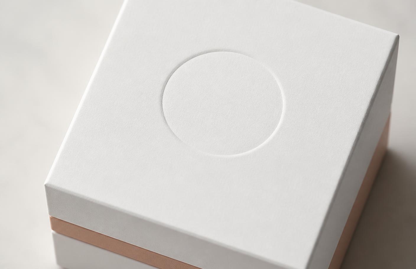 Matte white custom box with a debossed logo area and brand colour accent